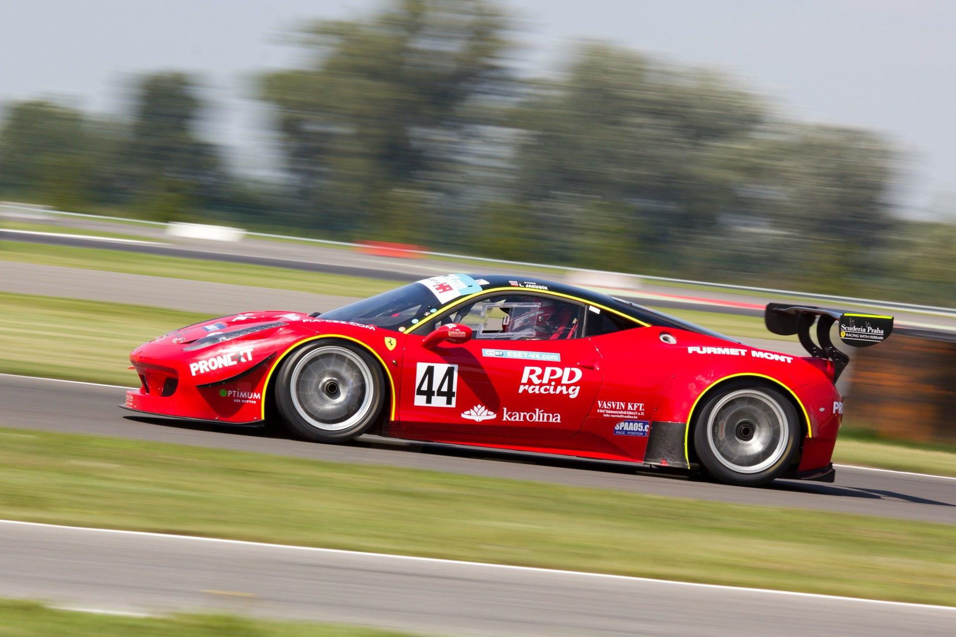 A red racing car sharply captured against a motion-blurred track.