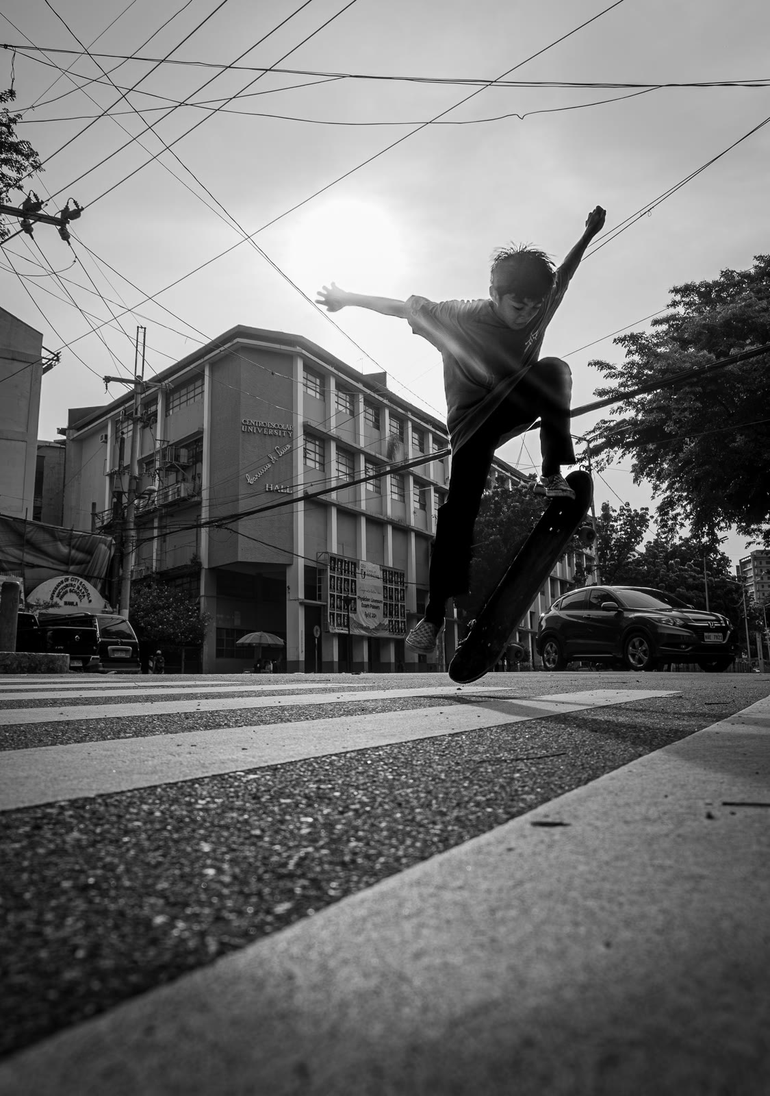 A skateboarder performing a street trick in black and white.